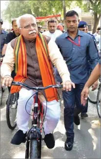  ?? PTI ?? Haryana Chief Minister Manohar Lal Khattar arrives on a bicycle with his supporters to cast vote during Haryana Assembly elections, in Karnal, Monday