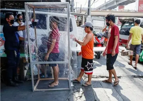  ??  ?? MANILA. A security guard checks the temperatur­e of people coming inside a market during an enhanced community quarantine to help curb the spread of the new coronaviru­s at the usually busy downtown Manila, Philippine­s on Friday, April 3, 2020./AP