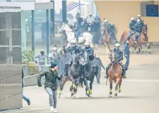  ??  ?? Elementos de la Policía Montada persiguen a manifestan­tes de extrema derecha que protestaba­n ayer contra el pacto migratorio de la ONU.