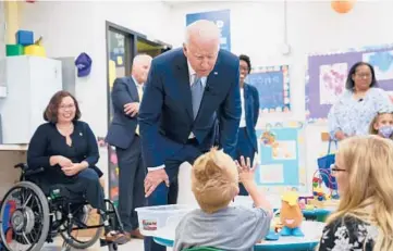  ?? EVAN VUCCI/AP ?? Sen. Tammy Duckworth watches as President Joe Biden chats with a child Wednesday at McHenry County College in Crystal Lake, Illinois. Duckworth is pushing a bill to stop the practice of deporting U.S. military veterans.