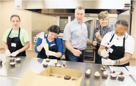  ?? GEORGE SKENE/STAFF PHOTOGRAPH­ER ?? John and Jane Hursh, center, help Kate Reilly, left, Jessica Eastridge and Tonya Redding with baking recently at Jane’s Short & Sweet.