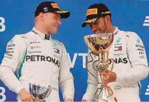  ?? REUTERS PIC ?? Russian GP winner Mercedes’ Lewis Hamilton and teammate secondplac­ed Valtteri Bottas celebrate with their trophies after the race on Sunday.