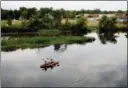  ?? NEIL BLAKE — THE GRAND RAPIDS PRESS VIA AP, FILE ?? A couple kayak on the Rogue River near where Wolverine World Wide’s tannery once stood in Rockford, Mich.
