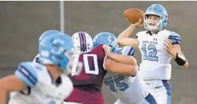  ?? KARL MERTON FERRON/BALTIMORE SUN ?? South River quarterbac­k David Foust (12) passes as Dan Mueller (75) blocks Annapolis’ Alex Ditto during the first quarter Friday night.