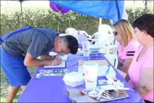  ?? WILLIAM ROLLER PHOTO ?? FROM LEFT: Jaime Arellano, registers for 5K race at the Brawley Cancer Walk Kick Off at the Between Women informatio­n tables Saturday in North Plaza.