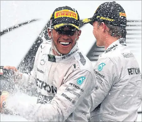  ?? Getty Images. ?? Lewis Hamilton celebrates on the podium with Mercedes team-mate Nico Rosberg, who finished second.