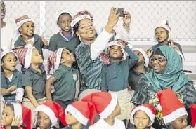  ??  ?? Pre-K teacher Antoinette Wiggins takes a selfie with her students before the Peach Bowl Inc. and the College Football Foundation teamed up to announce a $1 million dollar initiative to improve early childhood literacy among kindergart­en through fifth-...