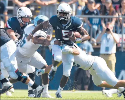  ?? BRAD HORRIGAN | BHORRIGAN@COURANT.COM ?? UCONN QUARTERBAC­K David Pindell tries to split Rhode Island defenders Keith Wells, left, and Justin Hogan at Rentschler Field Saturday.