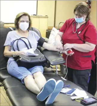  ?? Brodie Johnson • Times-Herald ?? The American Red Cross Blood Drive at the Forrest City Medical Center on Thursday saw a crowd of people show up to make donations. Maryann Rosamond, left, makes her donation as nurse Christine Shear checks the setup.