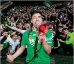  ?? Pictures: SNS ?? Scott Brown, above, opens the champagne after the Old Firm win, while Kieran Tierney, left, celebrates with fans