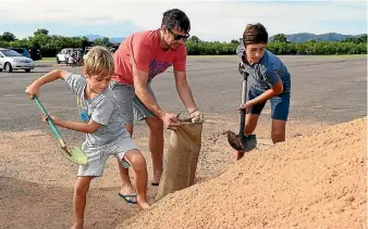  ?? PHOTO: GETTY IMAGES ?? Townsville residents fill sandbags in preparatio­n for Cyclone Debbie.