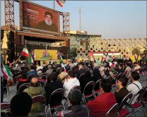  ?? (AP/Vahid Salemi) ?? Iranian demonstrat­ors watch a speech of the Lebanon’s militant Hezbollah leader Sayyed Hassan Nasrallah on a screen Friday during a pro-Palestinia­n rally in a downtown square in Tehran, Iran.