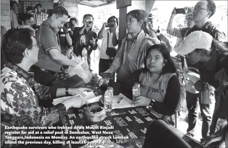  ?? Photo: AFP ?? Earthquake survivors who trekked down Mount Rinjani register for aid at a relief post in Sembalun, West Nusa Tenggara,Indonesia on Monday. An earthquake struck Lombok island the previous day, killing at least 16 people.