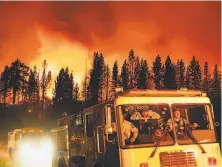  ?? Noah Berger / Associated Press ?? Firefighte­rs arrive Thursday to battle the Sugar Fire, part of the Beckwourth Complex Fire, burning in the Plumas National Forest north of Truckee. Containmen­t is dropping.