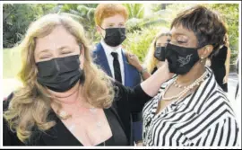  ??  ?? Butch Stewart’s widow Cheryl (left) and his personal assistant Arlene Lindo comfort each other at his funeral service yesterday at Rio Chico, St Ann. At centre is Stewart’s youngest son Gordon Jr.