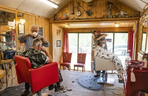  ?? Photos by Kelsey Brunner, The Aspen Times ?? Lonnie Bones and Chad Bones cut their clients’ hair in the Basalt Barber Shop in May 2020. Lonnie passed away from COVID-19 complicati­ons on Nov. 6.