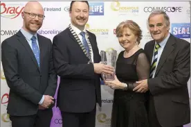  ??  ?? Stephen Donnelly TD and Pat Ó Suillebhái­n President of Bray Chamber presents the Person of the Year award to Geraldine Fitzharris with her husband Arthur