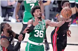  ?? AP Photo/Mark J. Terrill ?? ■ Boston Celtics guard Marcus Smart (36) competes for a rebound against Miami Heat’s Jae Crowder, left, and Bam Adebayo, right, during the an NBA Eastern Conference Finals game, Saturday in Lake Buena Vista, Fla.