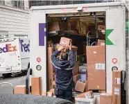  ?? Michael Nagle/Bloomberg ?? An independen­t contractor with FedEx unloads packages on Cyber Monday in New York.