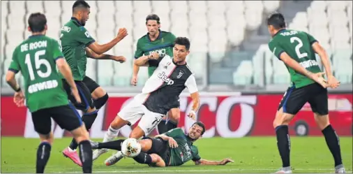  ??  ?? Cristiano, rodeado de jugadores del Atalanta, pugna por un balón durante el partido de ayer en el Allianz Stadium.