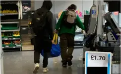  ?? ?? GETAWAY: Alleged thieves making off with bags full of items taken from shelves in a Co-op in Reading