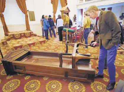  ?? BOB BROWN/RICHMOND TIMES-DISPATCH ?? House of Delegates Clerk G. Paul Nardo checks out the original Speaker’s chair before it is put inside the Old House Chamber at the State Capitol.