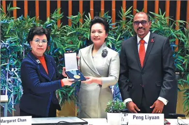  ?? XIE HUANCHI /XINHUA NEWS AGENCY ?? WHO Director-General Margaret Chan (left) presents a medal for outstandin­g service to first lady Peng Liyuan as UNAIDS Executive Director Michel Sidibe looks on.