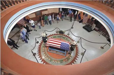  ?? ROB SCHUMACHER/THE REPUBLIC ?? Citizens pay their respects to Sen. John McCain as he lies in state in the Rotunda at the Arizona State Capitol, with an Arizona National Guard of Honor attending Wednesday in Phoenix.