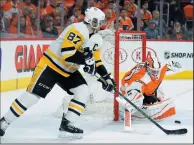  ?? AP PHOTO/TOM MIHALEK ?? Pittsburgh Penguins’ Sidney Crosby, left, tries for a goal as Philadelph­ia Flyers’ Brian Elliott defends during the first period in Game 4 of an NHL first-round playoff series Wednesday in Philadelph­ia. The Penguins won 5-0.