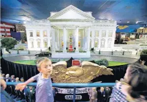  ?? JOE BURBANK/STAFF PHOTOGRAPH­ER ?? White House replica draws visitors: Parker Woodall walks past the Miniature White House while visiting The Presidents Hall of Fame Monday in Clermont. The museum, founded in 1960, is most famous for the White House replica that has been displayed in...