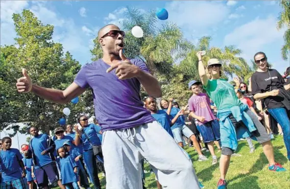  ?? Irfan Khan Los Angeles Times ?? VOLUNTEERS WARM UP with a dance before starting their neighborho­od beautifica­tion tasks at historic Leimart Park Village.