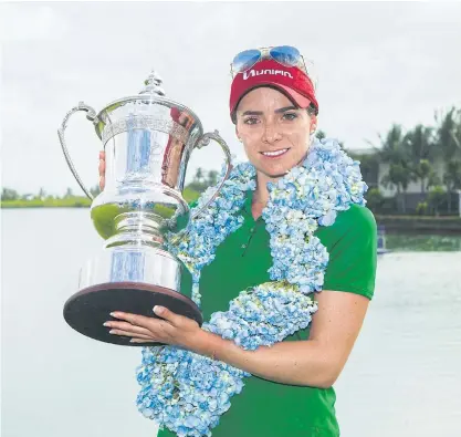  ??  ?? Gaby Lopez holds her trophy after winning the Blue Bay LPGA tournament in Sanya on China’s Hainan Island.
