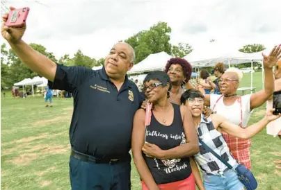  ?? AMY DAVIS/BALTIMORE SUN ?? Baltimore City Police Commission­er Michael Harrison takes a selfie with, from left, Kathy Berkley, Phyllis Purvis, Chevette Smith and Deidre Tisdale at the “Christmas in July Music Fest” organized by Hug Don’t Shoot. The fifth anniversar­y party brought hundreds to the Clifton Park bandshell, with vendors, back-to-school giveaways and food nearby.