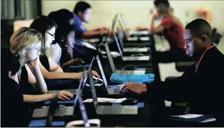  ?? Photo: AP ?? Job seekers work on their resumes during the Opportunit­y Fair and Forum employment event in Dallas, Texas. The US is moving closer to full employment.