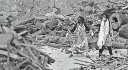  ?? AIJAZ RAHI/AP ?? A woman near Bengaluru, India, pulls away her relative as she reacts to the funeral pyre of a family member.