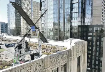  ?? Justin Sullivan Getty Images ?? WORKERS DISMANTLE a large X on the roof of the headquarte­rs of the former Twitter on July 31 after residents complained about bright lights and the city of San Francisco launched an inquiry into the structure.