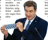  ?? FOTO: DPA ?? Bayerns Regierungs­chef Markus Söder (CSU) mit einer Atemschutz­maske in Landesfarb­en.