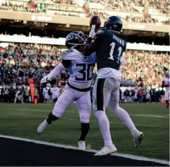  ?? MATT SLOCUM/AP ?? Eagles wide receiver A.J. Brown scores on a 29-yard TD catch in front of the Titans’ Tre Avery during the third quarter Sunday.