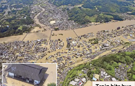  ?? AP ?? Large areas are inundated as residents seek refuge on the rooftop of a house (inset) submerged in muddy waters that gushed out from the Kuma River in Hitoyoshi, Kumamoto prefecture in southweste­rn Japan yesterday.