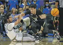  ?? Robert Gauthier Los Angeles Times ?? UCLA GUARD Tyger Campbell manages to get a pass off while falling down as Colorado guard KJ Simpson guards him. Campbell had 21 points and five assists.