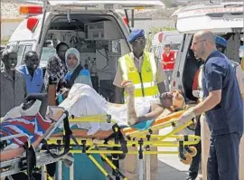  ?? Farah Abdi Warsameh Associated Press ?? A MAN CRITICALLY wounded in the attack in Mogadishu is wheeled toward an air ambulance that will transport him to Turkey for medical treatment.
