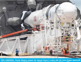  ??  ?? CAPE CANAVERAL, Florida: Workers prepare the SpaceX Falcon 9 rocket with the Crew Dragon spacecraft attached for today’s scheduled liftoff from launch pad 39A at the Kennedy Space Center. — AFP