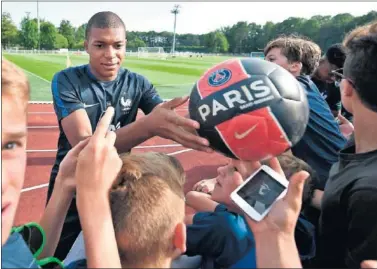  ??  ?? CON ‘LES BLEUS’. Mbappé firma autógrafos con Francia como jugador del PSG.