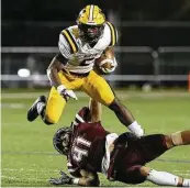  ?? Kin Man Hui / Staff photograph­er ?? Fort Bend Marshall's Devon Achane leaps over Corpus Christi Calallen's Matt Castro on Friday.