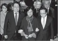  ?? AP/KIN CHEUNG ?? Selina Tsang (center), wife of former Hong Kong leader Donald Tsang, is accompanie­d by her sons, Simon Tsang Hing-yin (left) and Thomas Tsang Hing-shun, as they leave the High Court on Wednesday in Hong Kong.