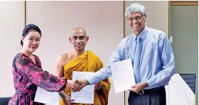  ??  ?? China Lvhai Technology Group representa­tive Luang Yizhen, Sadaham Sevana founder Athuraliye Rathana Thera and Strategic Enterprise Management Agency Chairman Asoka Abeygunawa­rdana after signing the agreement