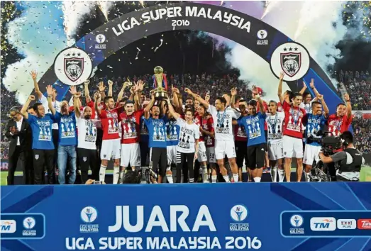  ?? — ABDUL RAHMAN EMBONG / The Star ?? Champs again: Johor Darul Ta’zim players lifting the 2016 Super League trophy at the Larkin Stadium in Johor Baru yesterday.