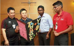  ??  ?? Creative: Kuan (second from left) impressed with the handmade card as Mohd Ridzuan (left) looks on with the company’s human resource (community affairs) executive RB yoges Balaras and Star Media Group audience management executive Sundarraja­n...