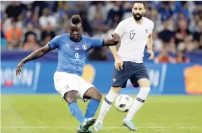  ?? AP ?? Italy’s Mario Balotelli (left) shoots while France’s Adil Rami looks on during their friendly internatio­nal match at the Allianz Riviera stadium in Nice, southern France, on Friday.