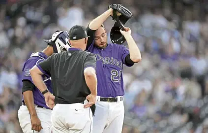  ?? David Zalubowski, The Associated Press ?? Rockies pitching coach Steve Foster confers with starting pitcher Austin Gomber during the first inning Saturday at Coors Field.